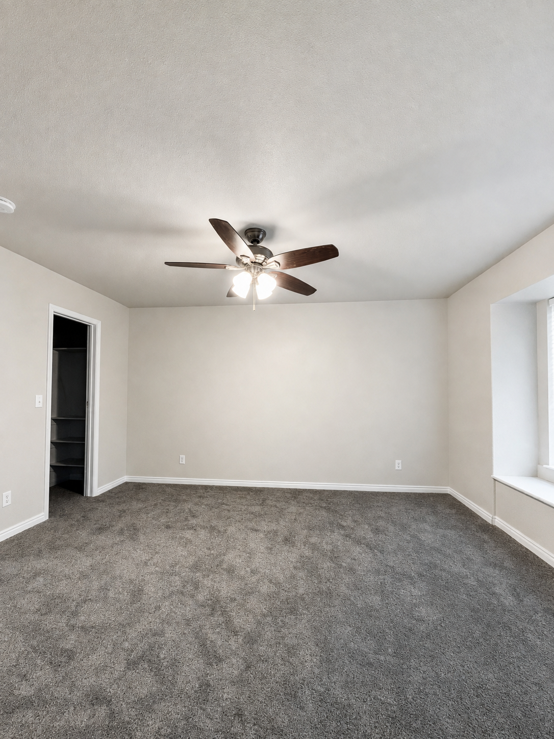 Finished bedroom with soft neutral walls, white trim, and gray carpet